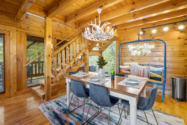 a view of a dining room with furniture a chandelier and wooden floor