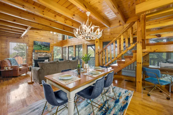 a view of a dining room with furniture a chandelier and wooden floor