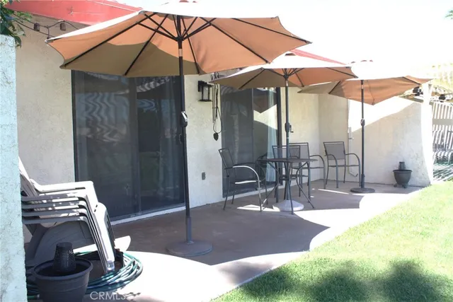 a view of a patio with table and chairs under an umbrella