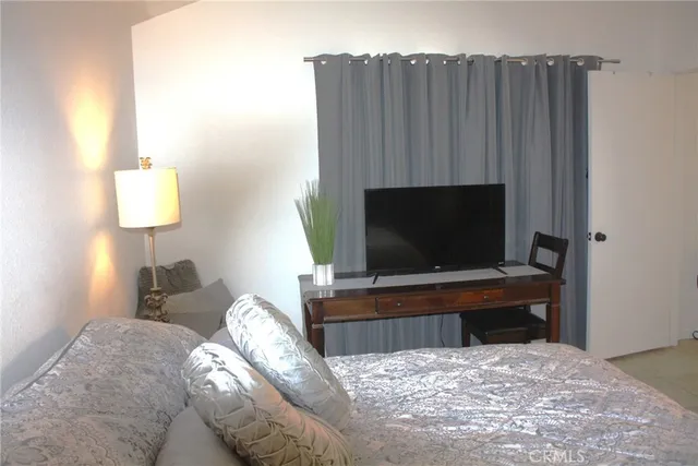 a bedroom with a bed and a television