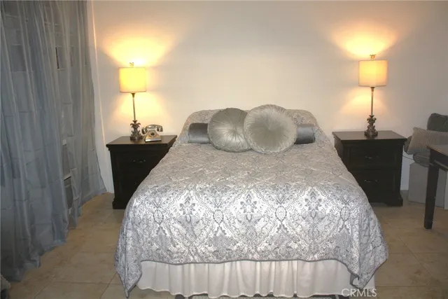 a bed sitting in a bedroom next to a lamp