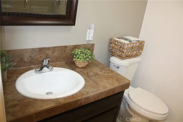 a bathroom with a sink a toilet and a mirror