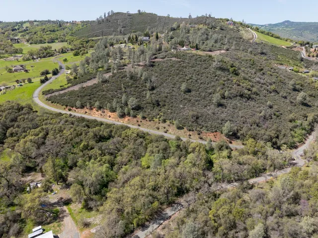 an aerial view of mountain with trees around