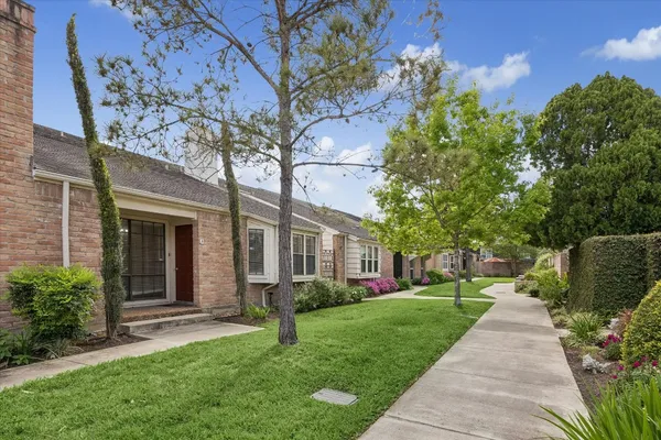 a front view of a house with a yard and potted plants