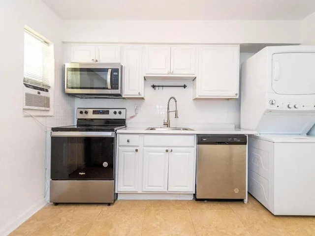 a kitchen with stainless steel appliances a stove microwave and sink