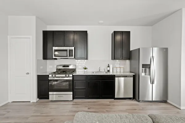 a kitchen with stainless steel appliances granite countertop a refrigerator stove and sink
