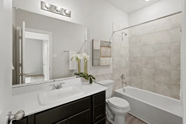 a bathroom with a double vanity sink toilet mirror and bathtub
