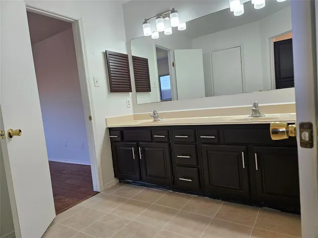 a bathroom with a granite countertop sink a large mirror and a shower