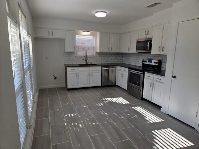 a kitchen with a sink stove and microwave