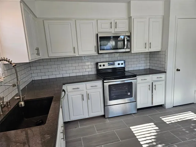a kitchen with cabinets stainless steel appliances and a counter space