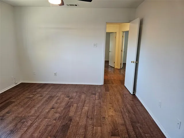 a view of a room with wooden floor and white walls