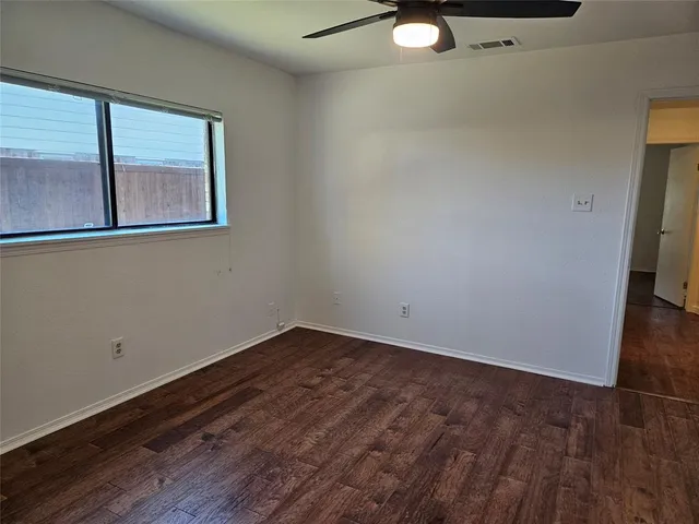 a view of a room with wooden floor and window