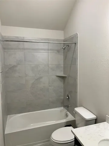 a bathroom with a toilet and a bath tub