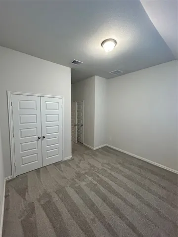 an empty room with closet and natural light