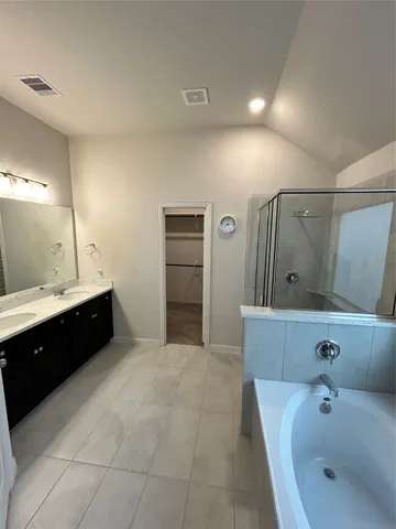 a spacious bathroom with a tub sink and mirror