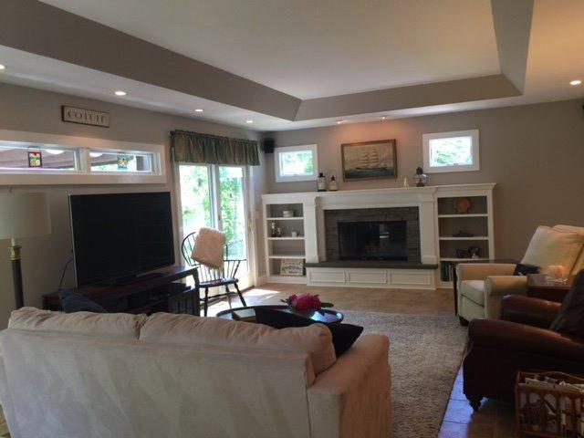 43 Poponessett Road Cotuit, MA 02635 - Photo 13 of 31 a living room with furniture flat screen tv and a fireplace