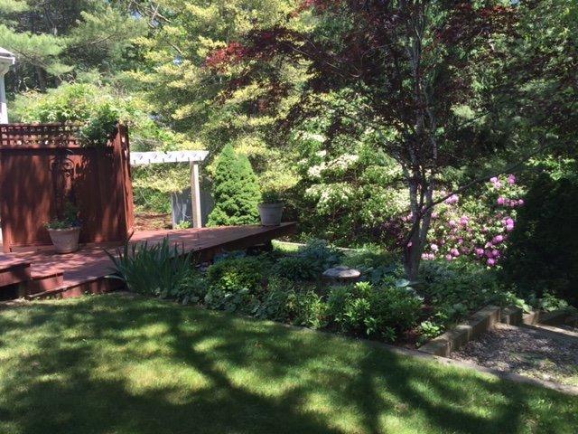 43 Poponessett Road Cotuit, MA 02635 - Photo 29 of 31 a backyard of a house with lots of green space and outdoor seating