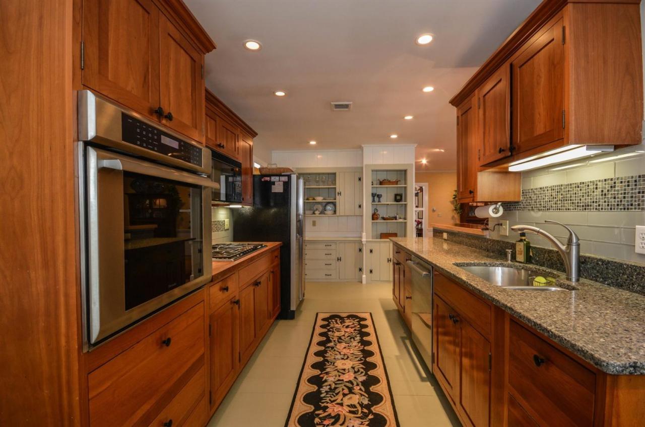 43 Poponessett Road Cotuit, MA 02635 - Photo 10 of 31 a kitchen with stainless steel appliances granite countertop a sink stove and cabinets