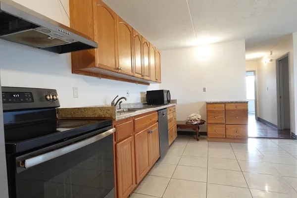 a view of kitchen with stainless steel appliances granite countertop a stove top oven and cabinets