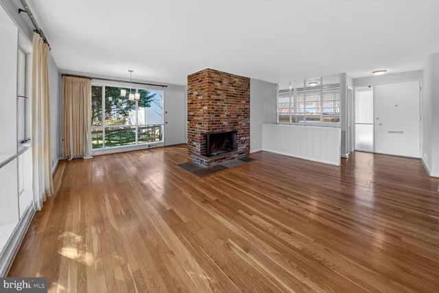 a view of a livingroom with wooden floor and a fireplace