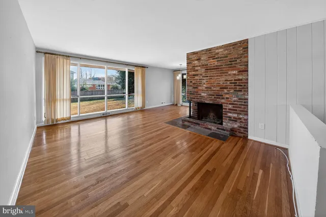 wooden floor fireplace and windows in an empty room