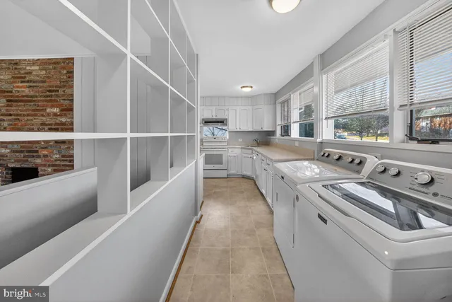 a kitchen that has a lot of cabinets in it and wooden floor