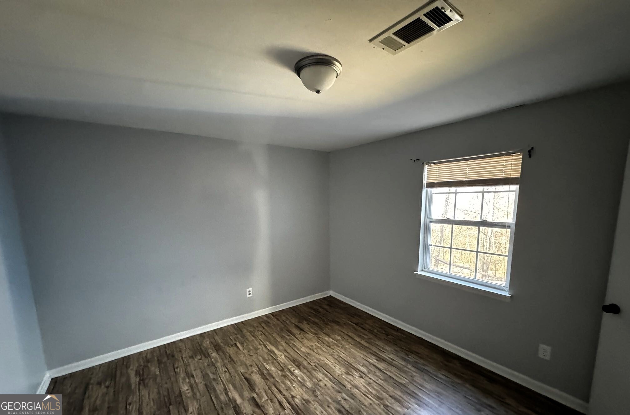 1614 Kendall Road Rocky Face, GA 30740 - Photo 7 of 10 an empty room with wooden floor and windows