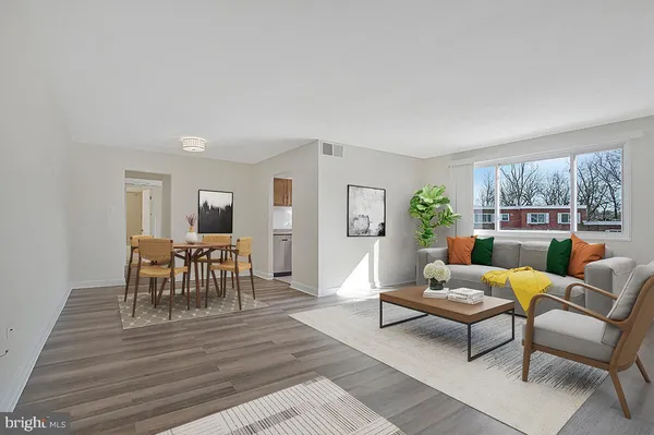 a living room with furniture wooden floor and a window