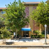 a living room with fireplace furniture a flat screen tv and a large window