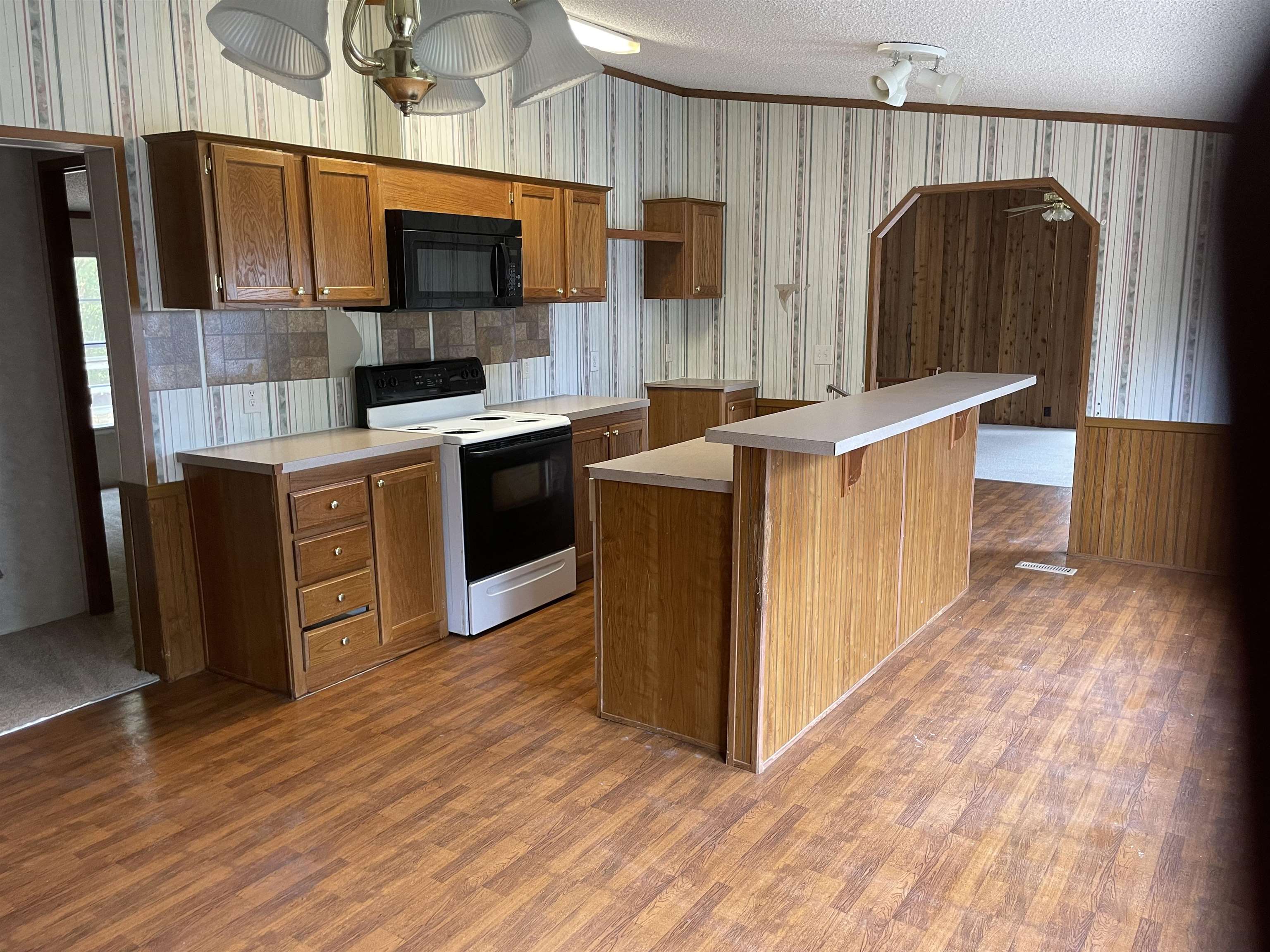 709 Robertson Road Mason, TN 38049 - Photo 5 of 16 a kitchen with stainless steel appliances a stove top oven a sink dishwasher and a refrigerator with wooden floor