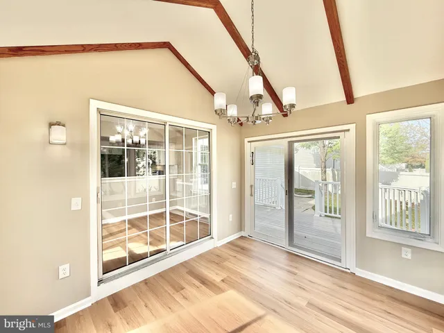 an empty room with windows and ceiling fan