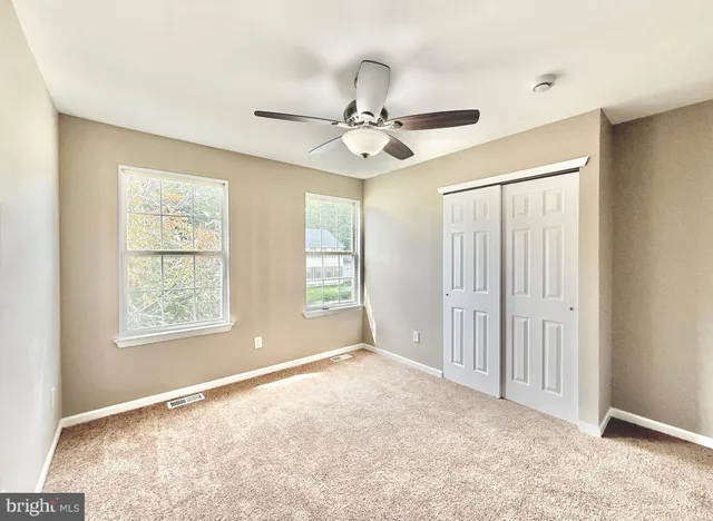 a bathroom with a granite countertop toilet sink and mirror