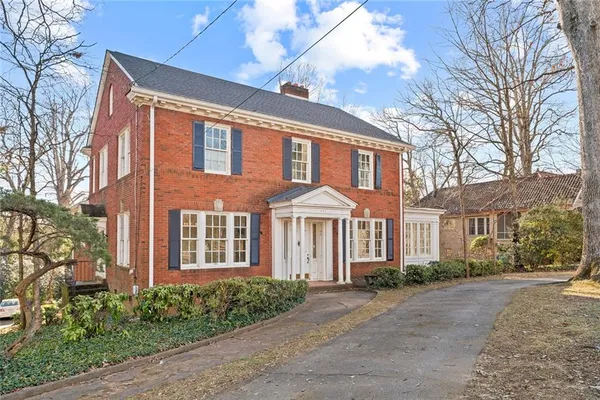 a front view of a house with a yard and trees