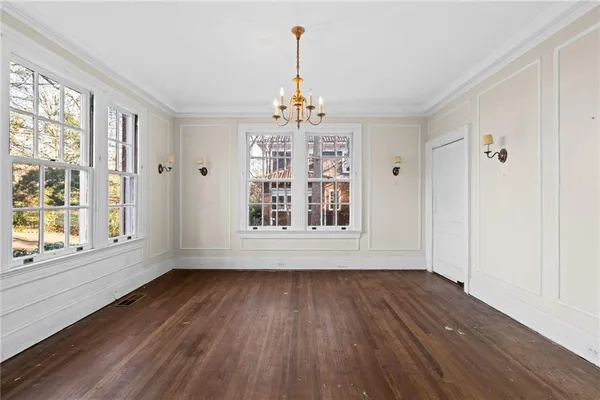 a view of an empty room with wooden floor fireplace and a window