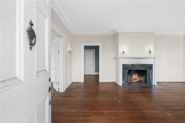a view of an empty room with wooden floor and windows