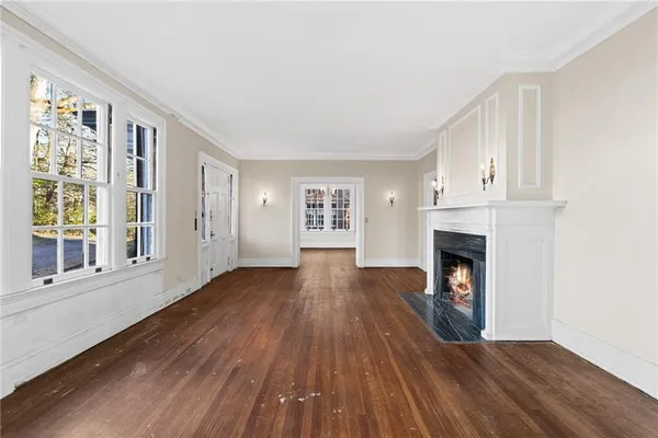 a view of empty room with wooden floor and fireplace