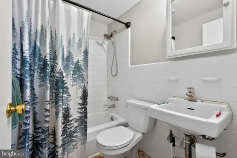 a bathroom with a sink a toilet and shower curtain