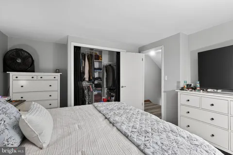 a bedroom with a bed and a flat screen tv in white dresser