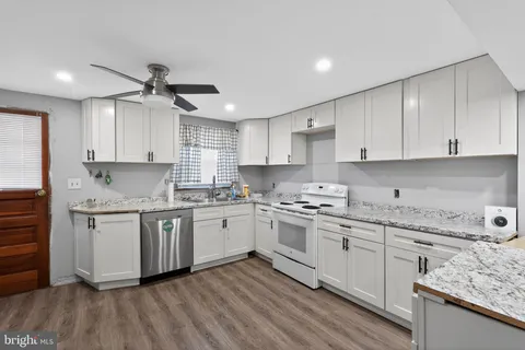 a kitchen with granite countertop cabinets stainless steel appliances a sink and a stove