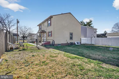 a view of backyard of house with wooden fence