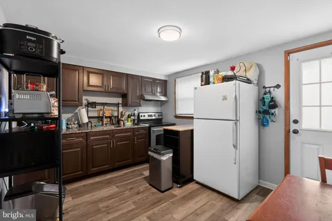 a kitchen with a refrigerator and a stove top oven