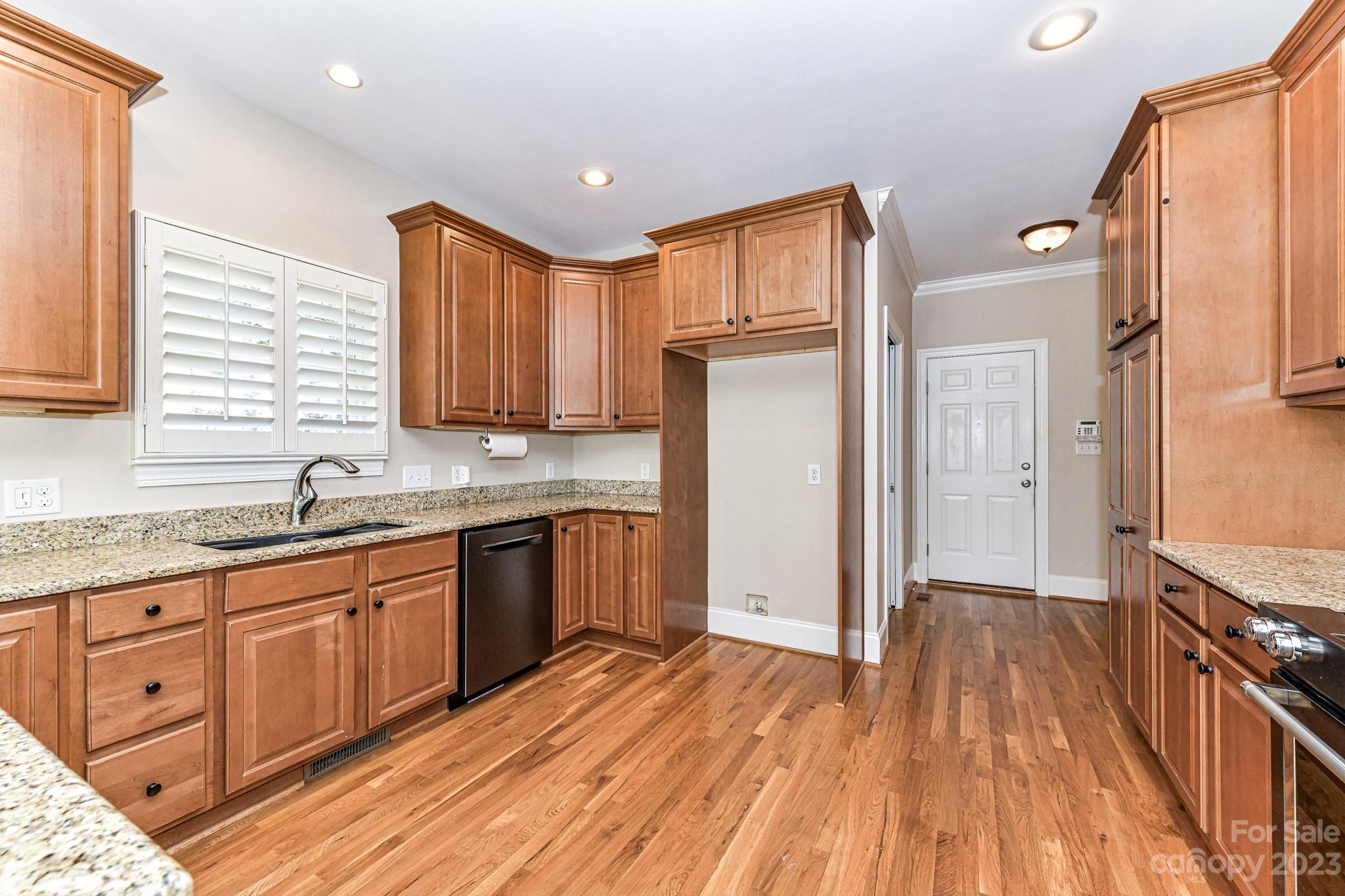 151 Maple View Drive Troutman, NC 28166 - Photo 12 of 43 a kitchen with stainless steel appliances granite countertop a refrigerator a sink dishwasher a stove and white countertops with wooden floor