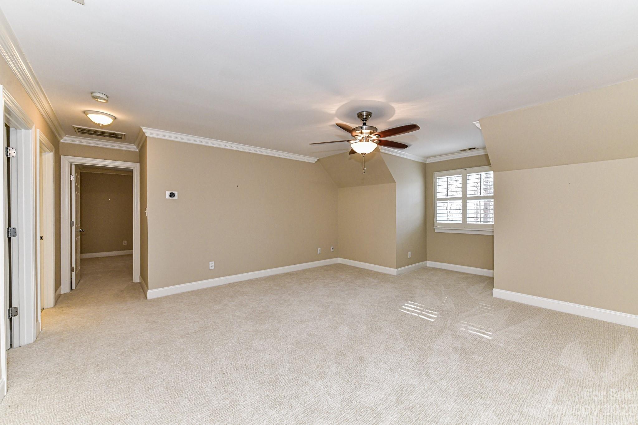 151 Maple View Drive Troutman, NC 28166 - Photo 22 of 43 an empty room with chandelier fan and windows