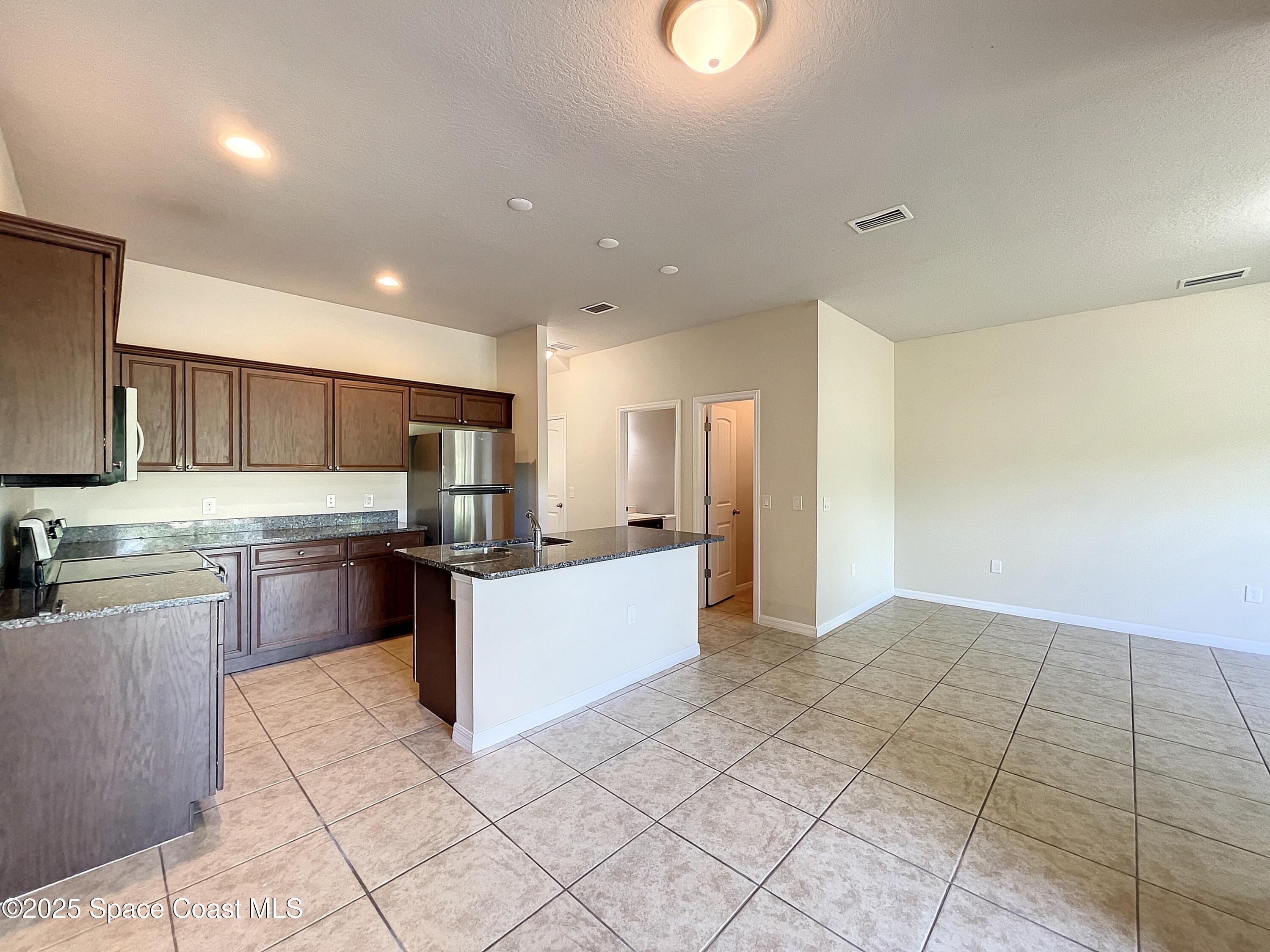 3737 Chambers Lane, Unit 8 Cocoa, FL 32926 - Photo 6 of 24 a large kitchen with a large counter top appliances and cabinets