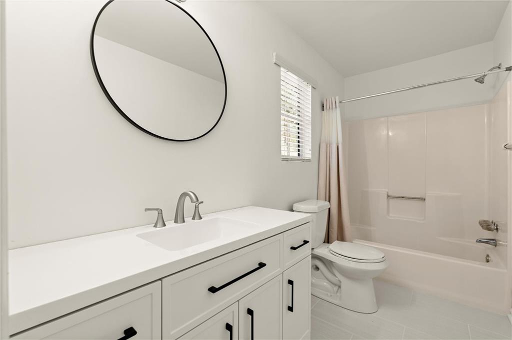 5984 Brookside Court Southeast Mableton, GA 30126 - Photo 11 of 21 a bathroom with a sink a mirror a toilet and a shower