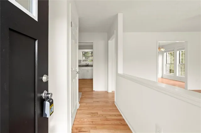 a view of a hallway with wooden floor and staircase