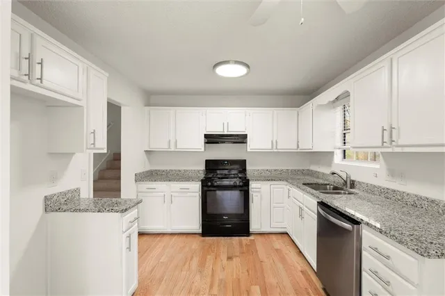 a kitchen with granite countertop a stove top oven sink and cabinets