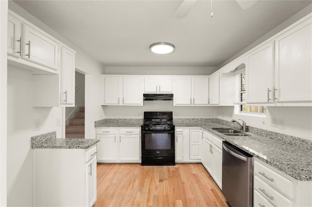 5984 Brookside Court Southeast Mableton, GA 30126 - Photo 6 of 21 a kitchen with granite countertop a stove top oven sink and cabinets