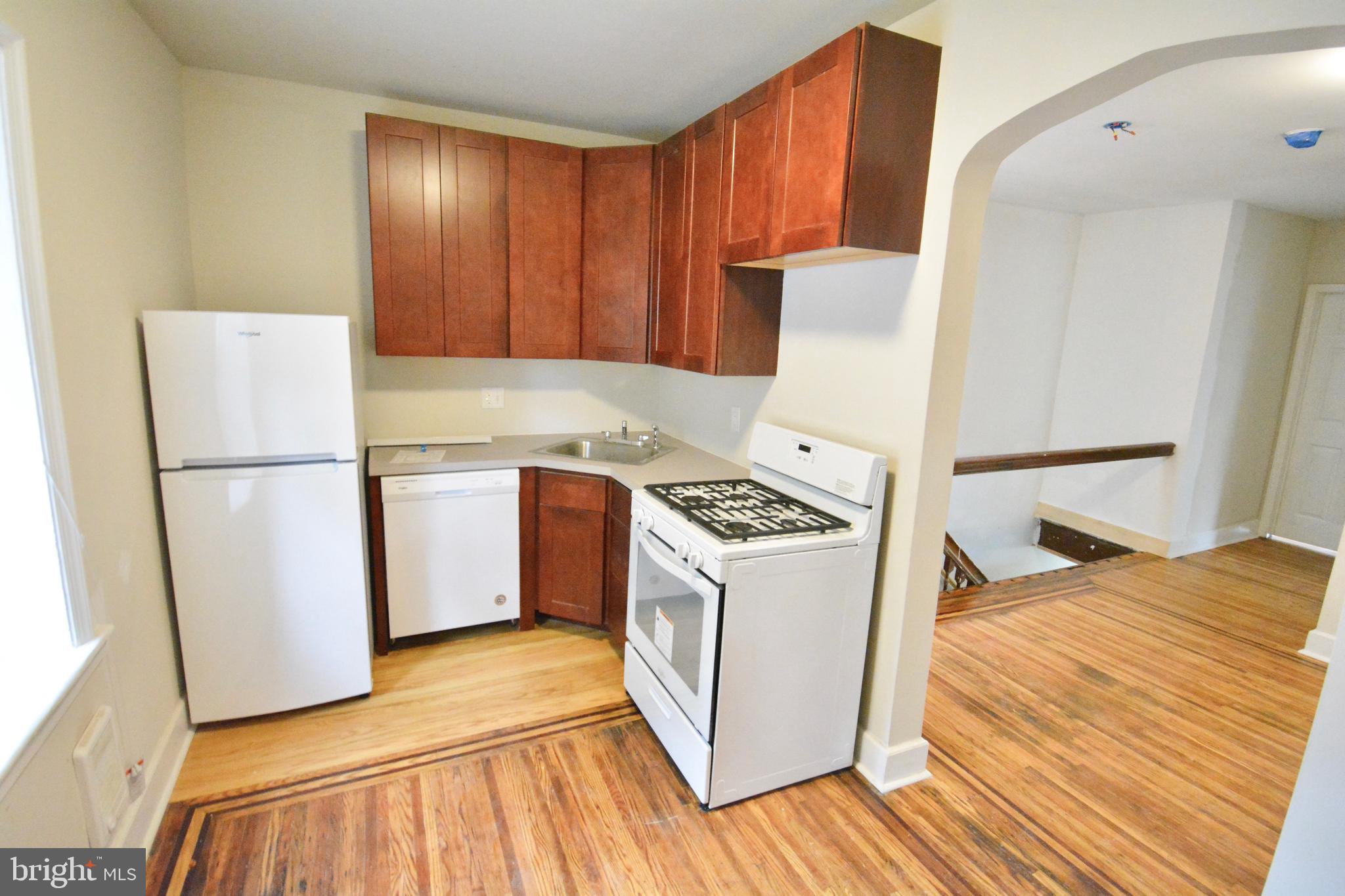 130 Manheim Street, Unit 3 Philadelphia, PA 19144 - Photo 5 of 14 a kitchen with a sink a stove a refrigerator and cabinets