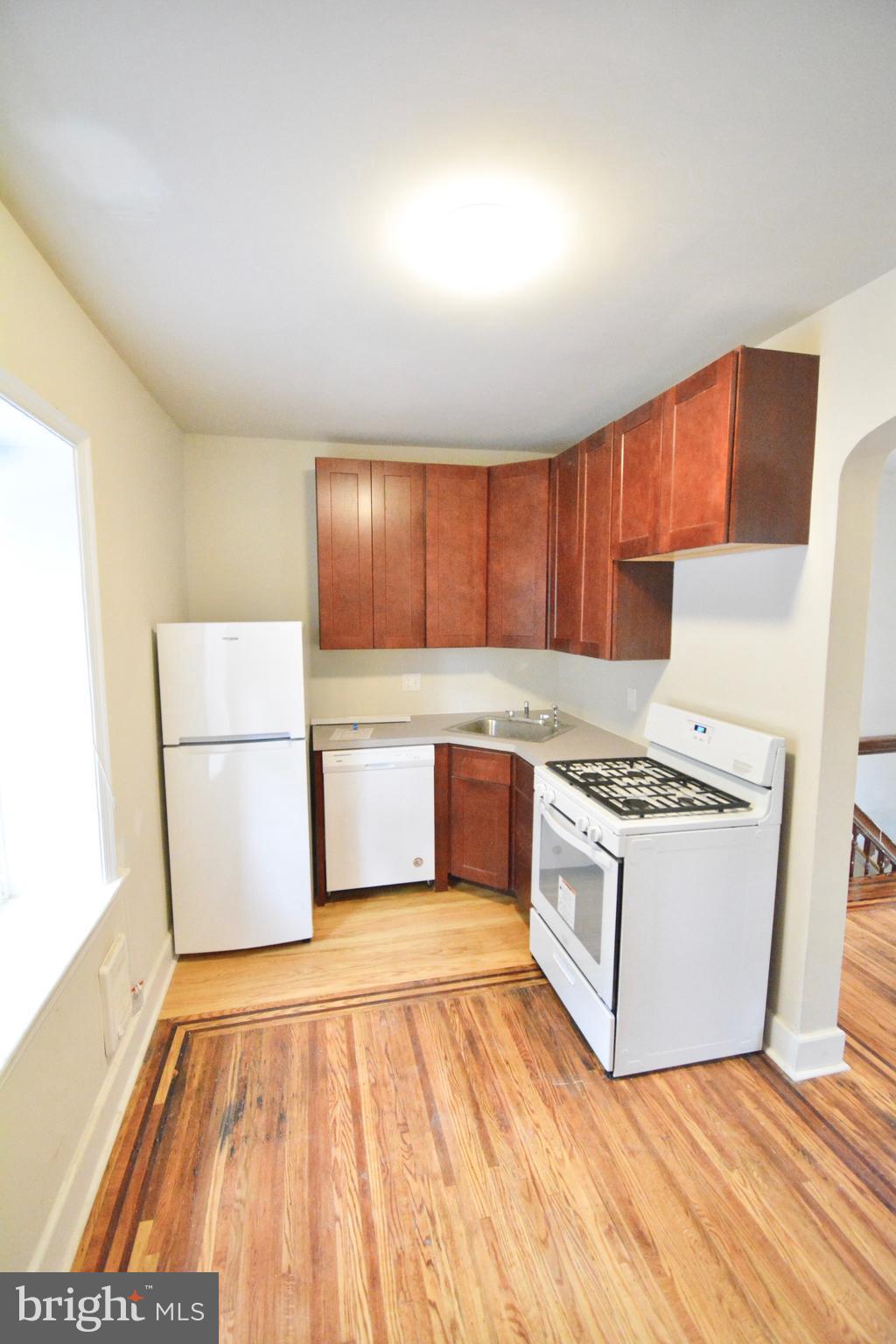 130 Manheim Street, Unit 3 Philadelphia, PA 19144 - Photo 7 of 14 a kitchen with a stove a sink and a refrigerator
